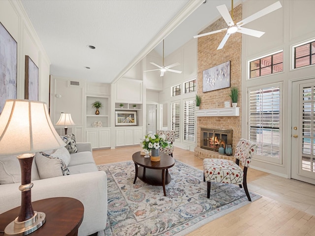 1735 Hodge Lake Ln, Sugar Land, TX 77478 - living room featuring ceiling fan, healthy amount of natural light, high vaulted ceiling, a fireplace, and built in shelves