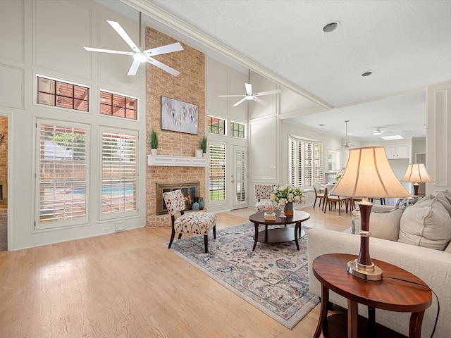 1735 Hodge Lake Ln, Sugar Land, TX 77478 - living area with a ceiling fan, a decorative wall, crown molding, a high ceiling, and a brick fireplace