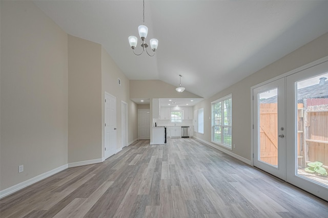 5130 Beaverhollow Dr, Houston, TX 77084 - unfurnished living room with light wood-style flooring, vaulted ceiling, a chandelier, baseboards, and french doors