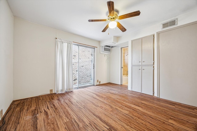 1849 Marshall St Unit 1, Houston, TX 77098 - unfurnished bedroom with wood finished floors, a wall mounted air conditioner, and ceiling fan