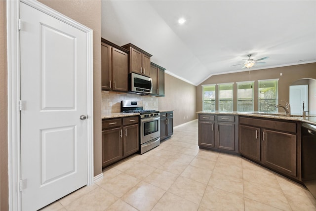 18934 Sorrento Point Dr, New Caney, TX 77357 - kitchen with appliances with stainless steel finishes, a sink, vaulted ceiling, a ceiling fan, and decorative backsplash