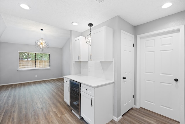 2314 Peaceful Valley Dr, Spring, TX 77373 - kitchen featuring beverage cooler, wood finished floors, white cabinetry, light countertops, and hanging light fixtures