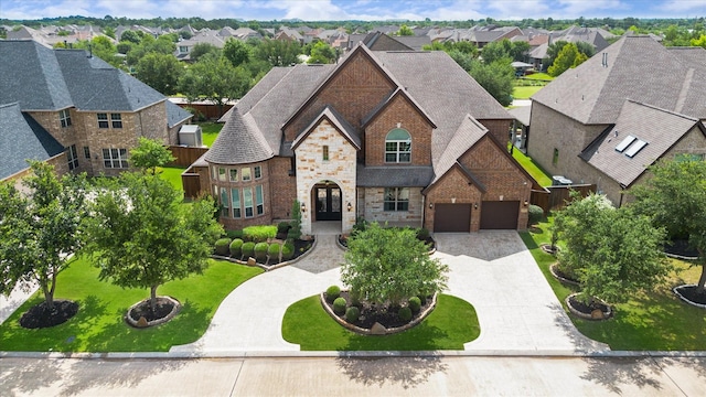10306 Grape Creek Grove Ln, Cypress, TX 77433 - french country style house featuring a residential view, brick siding, driveway, a garage, and stone siding