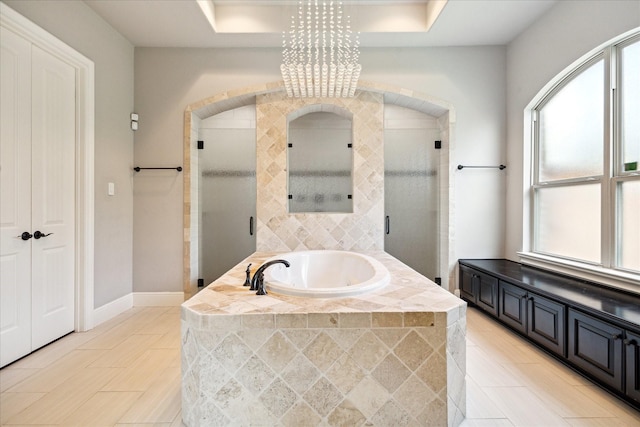 10306 Grape Creek Grove Ln, Cypress, TX 77433 - full bath featuring healthy amount of natural light, a bath, a shower stall, and a chandelier