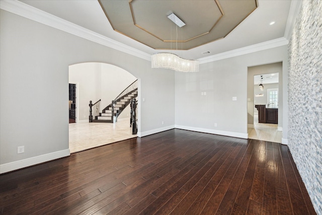 10306 Grape Creek Grove Ln, Cypress, TX 77433 - unfurnished room with a tray ceiling, stairway, arched walkways, wood finished floors, and crown molding