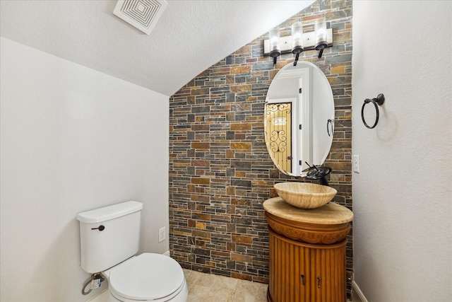 10306 Grape Creek Grove Ln, Cypress, TX 77433 - half bath featuring lofted ceiling, toilet, vanity, and a textured ceiling