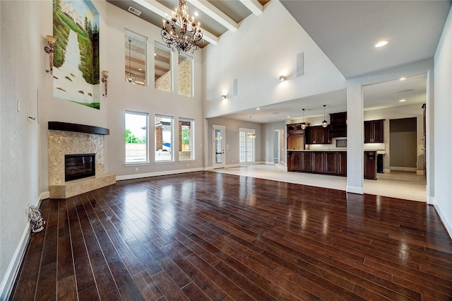 10306 Grape Creek Grove Ln, Cypress, TX 77433 - unfurnished living room featuring a fireplace, baseboards, a chandelier, wood finished floors, and a high ceiling