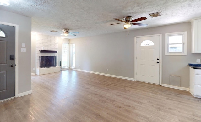 3907 Texas Ave, Dickinson, TX 77539 - unfurnished living room with ceiling fan, a textured ceiling, light wood-type flooring, and baseboards