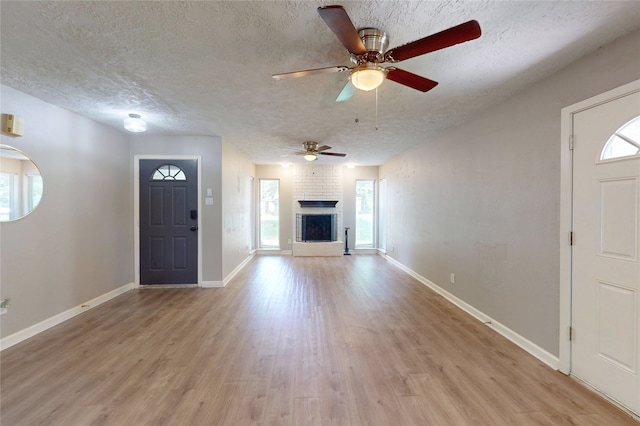 3907 Texas Ave, Dickinson, TX 77539 - entrance foyer featuring healthy amount of natural light, light wood-style floors, ceiling fan, a textured ceiling, and a fireplace