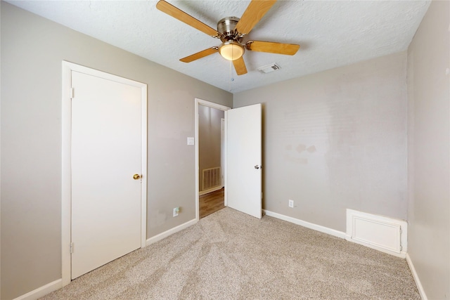 3907 Texas Ave, Dickinson, TX 77539 - unfurnished bedroom featuring carpet, baseboards, a ceiling fan, and a textured ceiling