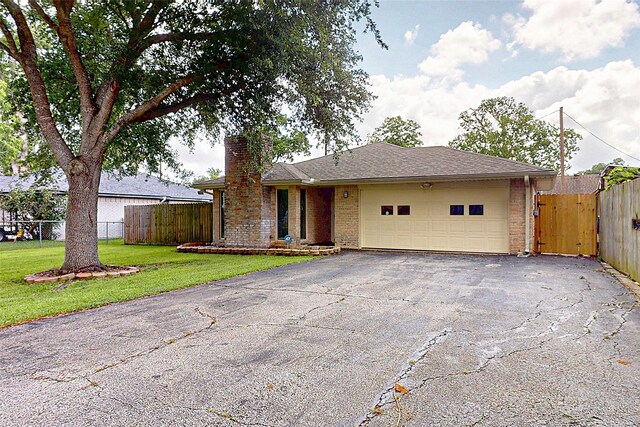 3907 Texas Ave, Dickinson, TX 77539 - ranch-style home featuring driveway, a chimney, a garage, and brick siding