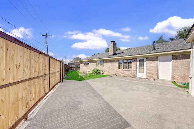 8007 Twin Hills Dr, Houston, TX 77071 - rear view of property with a chimney, brick siding, and roof with shingles