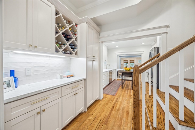 1336 Tulane St, Houston, TX 77008 - bar area featuring dishwasher, light wood-type flooring, tasteful backsplash, crown molding, and stairs