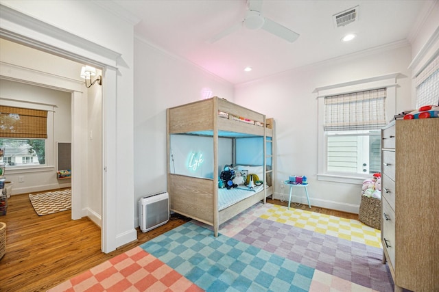 1336 Tulane St, Houston, TX 77008 - bedroom with ornamental molding, wood finished floors, baseboards, heating unit, and a ceiling fan
