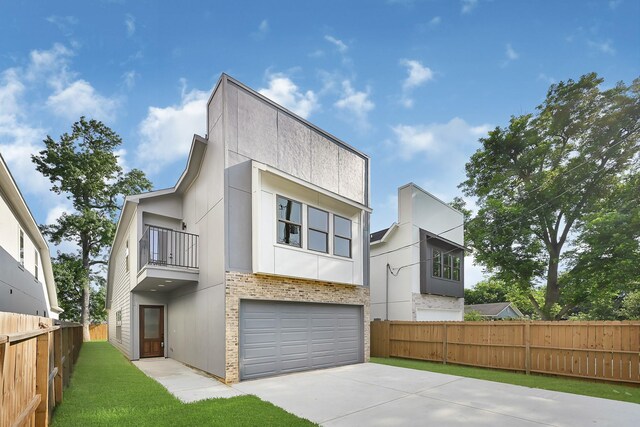 90 Burres St Unit B, Houston, TX 77022 - contemporary home featuring a balcony, driveway, an attached garage, stucco siding, and brick siding