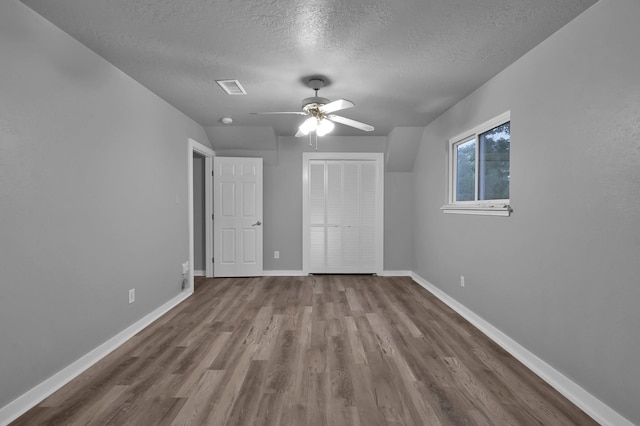 402 Pine Manor Dr, Conroe, TX 77385 - unfurnished bedroom with a textured ceiling, wood finished floors, baseboards, a closet, and a ceiling fan