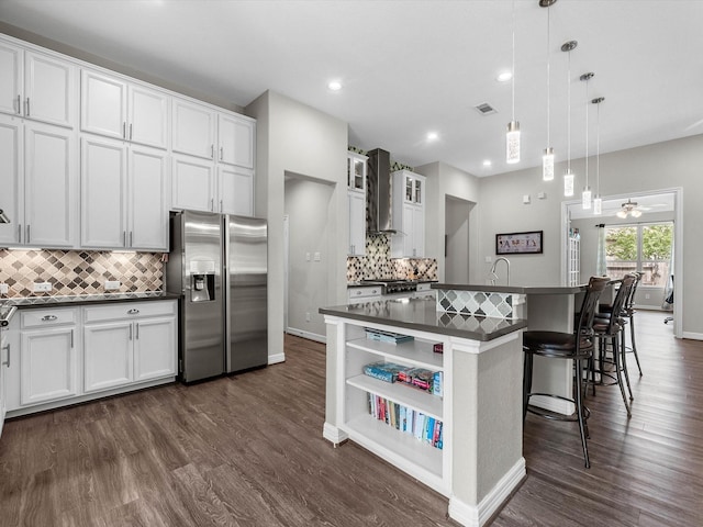3466 Oakheath Manor Way, Houston, TX 77365 - kitchen featuring stainless steel refrigerator with ice dispenser, dark countertops, decorative backsplash, a center island with sink, and recessed lighting