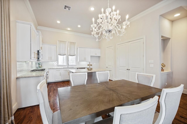 2713 Cohn Gdn, Houston, TX 77007 - dining area with crown molding, a chandelier, dark wood-type flooring, and recessed lighting
