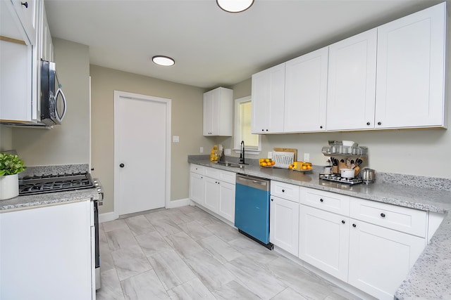 5906 Melanite Ave, Houston, TX 77053 - kitchen with appliances with stainless steel finishes, a sink, white cabinetry, and baseboards