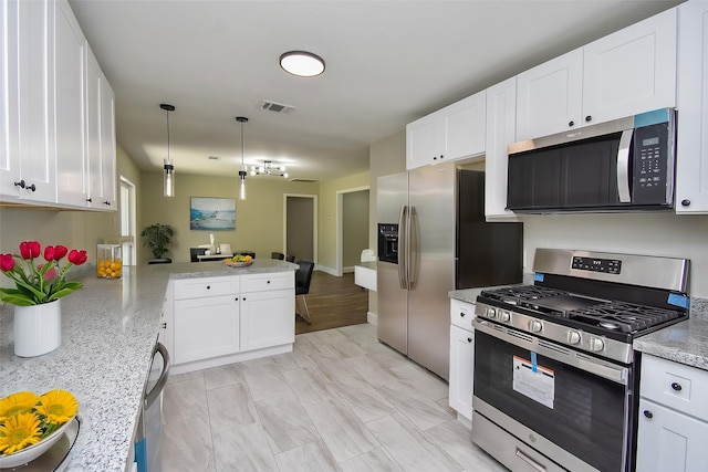 5906 Melanite Ave, Houston, TX 77053 - kitchen featuring appliances with stainless steel finishes, a peninsula, white cabinetry, and hanging light fixtures