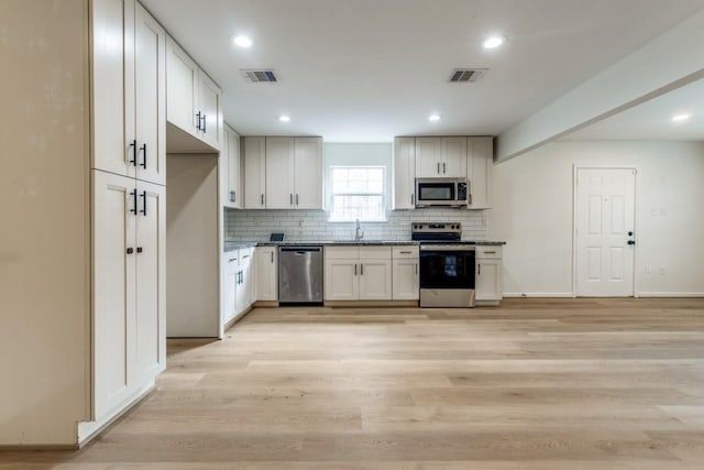 6626 Saint Augustine St, Houston, TX 77021 - kitchen featuring stainless steel appliances, a sink, decorative backsplash, light wood-type flooring, and recessed lighting