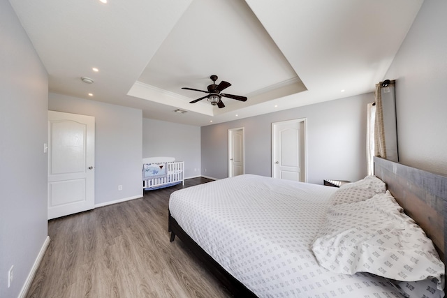 8106 Sweetstone Bluff Ln, Cypress, TX 77433 - bedroom with baseboards, a tray ceiling, wood finished floors, ceiling fan, and recessed lighting