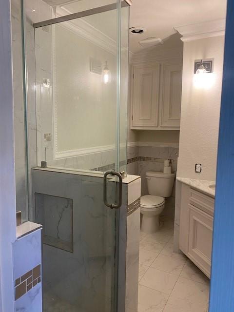 8107 S Braeswood Blvd, Houston, TX 77071 - bathroom featuring ornamental molding, vanity, a shower stall, toilet, and marble look tiles