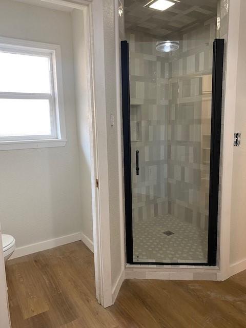 8107 S Braeswood Blvd, Houston, TX 77071 - full bath featuring a stall shower, wood finished floors, toilet, and baseboards