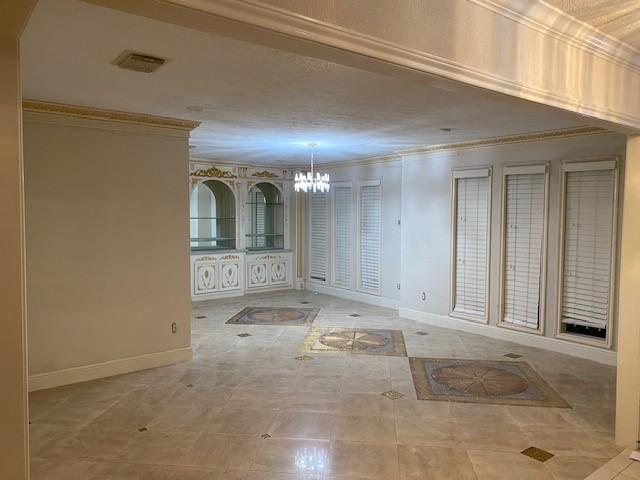8107 S Braeswood Blvd, Houston, TX 77071 - hall featuring a chandelier, baseboards, and ornamental molding