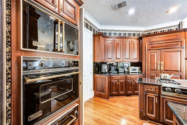 5302 Val Verde St, Houston, TX 77056 - kitchen featuring appliances with stainless steel finishes, ornamental molding, a textured ceiling, light wood-style floors, and dark stone countertops