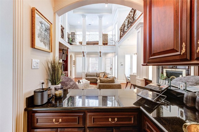 5302 Val Verde St, Houston, TX 77056 - kitchen with ornamental molding, arched walkways, a high ceiling, open floor plan, and dark stone countertops