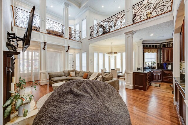 5302 Val Verde St, Houston, TX 77056 - living area featuring decorative columns, crown molding, a high ceiling, plenty of natural light, and a chandelier