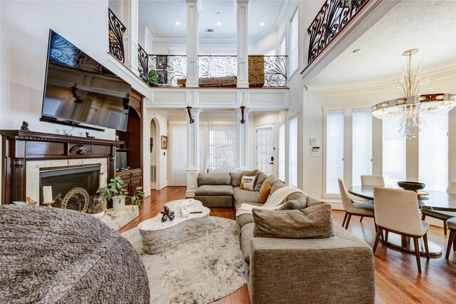 5302 Val Verde St, Houston, TX 77056 - living area with a chandelier, ornamental molding, a fireplace, arched walkways, and wood finished floors