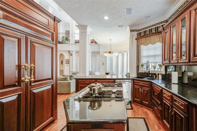5302 Val Verde St, Houston, TX 77056 - kitchen featuring a sink, crown molding, a kitchen island, light wood finished floors, and a textured ceiling