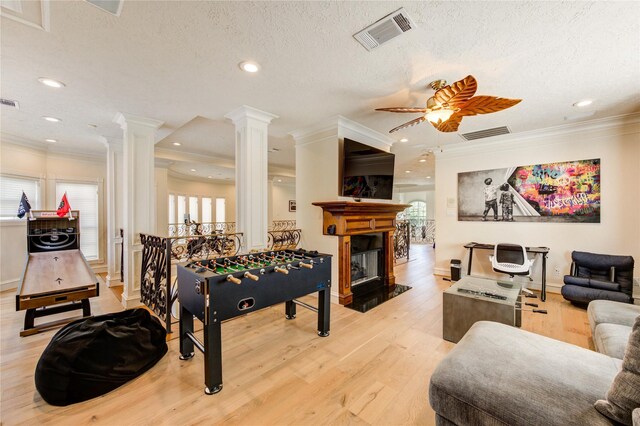 5302 Val Verde St, Houston, TX 77056 - game room featuring ornate columns, crown molding, light wood-style flooring, a ceiling fan, and a glass covered fireplace