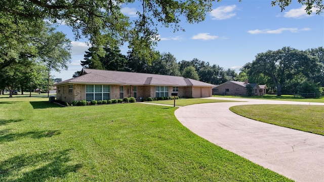 534 W Hufsmith Rd, Tomball, TX 77375 - ranch-style house featuring curved driveway, a front lawn, a garage, and brick siding