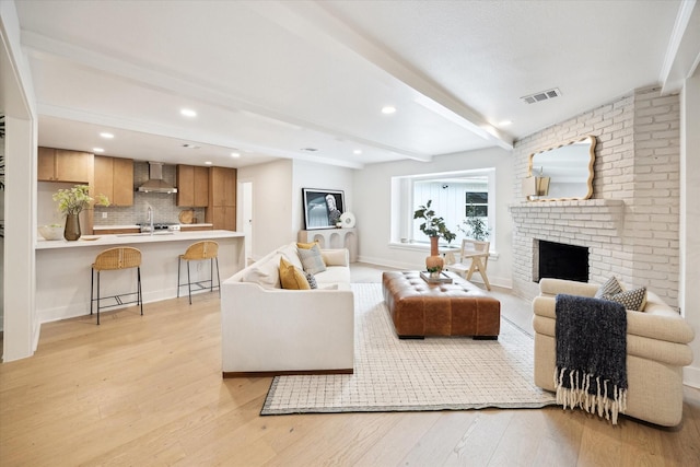 4411 Colchester St, Houston, TX 77018 - living room featuring beam ceiling, light wood finished floors, a brick fireplace, recessed lighting, and baseboards