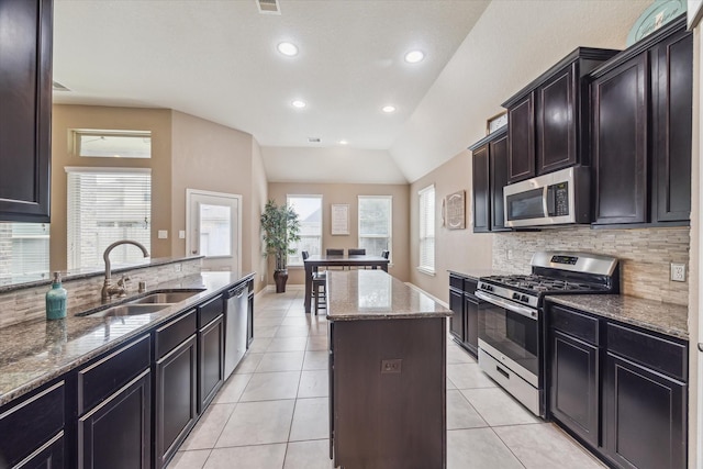 4914 Mountain Maple Trl, Rosenberg, TX 77471 - kitchen with appliances with stainless steel finishes, a sink, tasteful backsplash, stone counters, and a center island