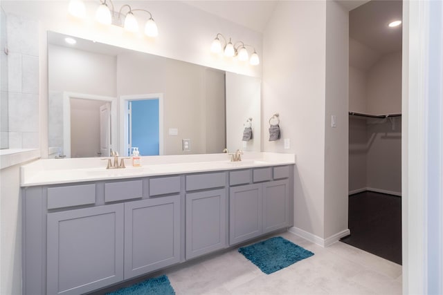 7334 Lake Arrowhead Ln, Porter, TX 77365 - full bathroom with double vanity, a walk in closet, baseboards, and lofted ceiling