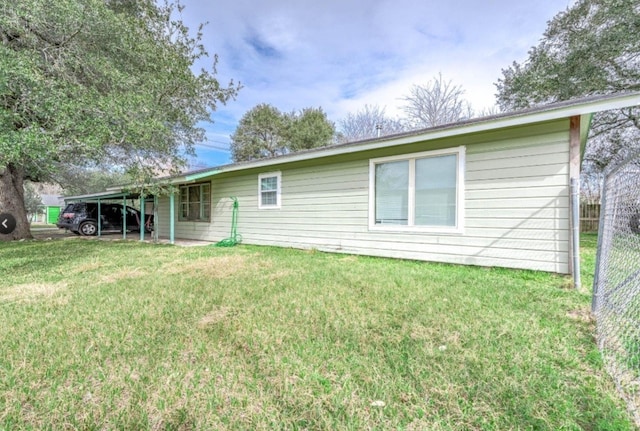 701 Alamo St, El Campo, TX 77437 - rear view of property featuring an attached carport
