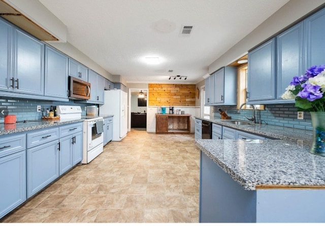 701 Alamo St, El Campo, TX 77437 - kitchen featuring white appliances, blue cabinetry, and decorative backsplash