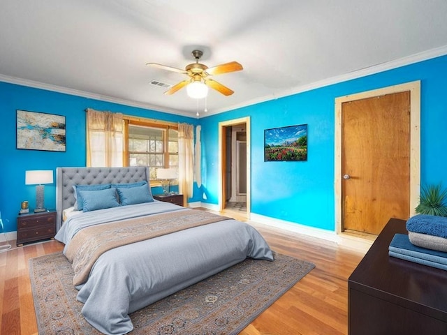 701 Alamo St, El Campo, TX 77437 - bedroom with crown molding, baseboards, light wood-style floors, and ceiling fan