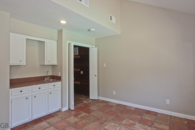 918 Longview Dr, Sugar Land, TX 77478 - kitchen featuring a sink, dark countertops, white cabinetry, baseboards, and recessed lighting