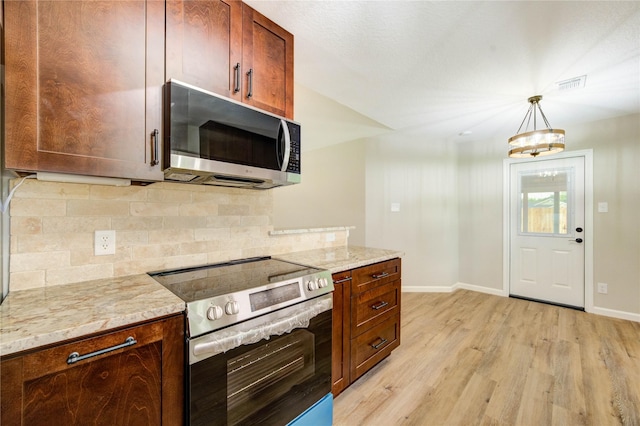 2525 29th Ave N, Texas City, TX 77590 - kitchen with appliances with stainless steel finishes, baseboards, light wood-style floors, and backsplash