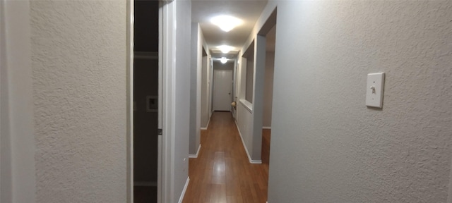 2518 Skyview Cove Ct, Houston, TX 77047 - hallway featuring wood finished floors, a textured wall, and baseboards