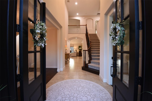4511 Wickby St, Fulshear, TX 77441 - entryway with french doors, arched walkways, stairs, a high ceiling, and light tile patterned flooring