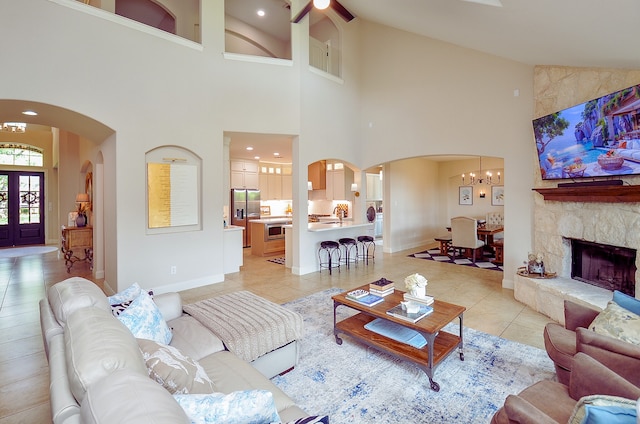 4511 Wickby St, Fulshear, TX 77441 - living area featuring arched walkways, light tile patterned floors, high vaulted ceiling, a chandelier, and a ceiling fan