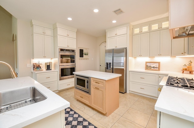 4511 Wickby St, Fulshear, TX 77441 - kitchen with appliances with stainless steel finishes, recessed lighting, a kitchen island, light stone countertops, and glass insert cabinets