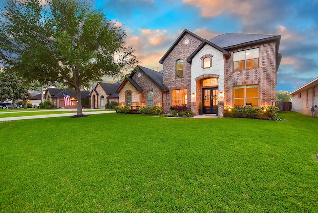 4511 Wickby St, Fulshear, TX 77441 - french country style house featuring brick siding, a front yard, french doors, and stone siding