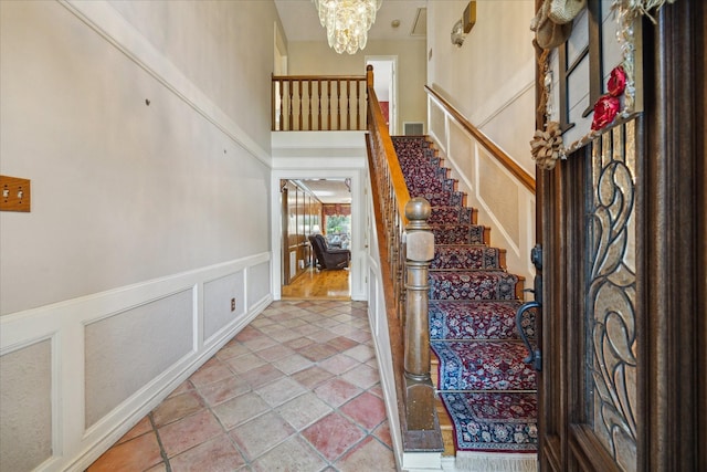 5718 Glenmere Ln, Spring, TX 77379 - foyer with a decorative wall, stairway, a chandelier, wainscoting, and a high ceiling